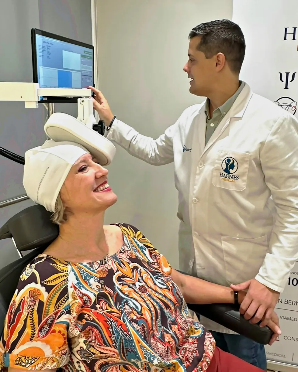 Técnico de la Unidad de Neuromodulación ajustando la bobina de estimulación magnética transcraneal (EMT) a una paciente, HAGNES Medical Sevilla